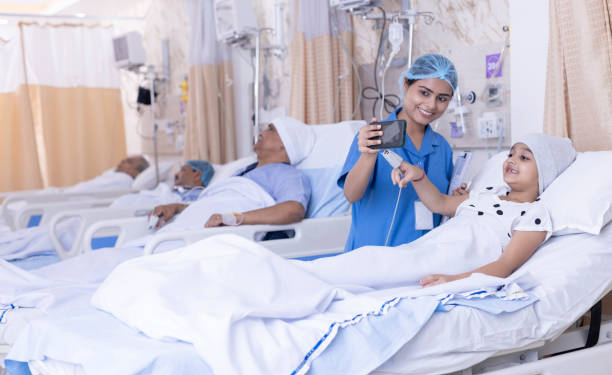 Young nurse consoling little girl patient lying on bed in hospital ward