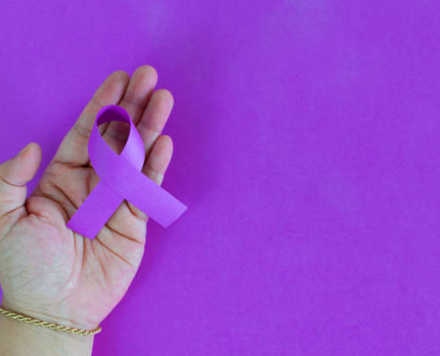 closeup of a hand woman with a purple ribbon, for the awareness about the unacceptability of the violence against women. International Day for the Elimination of Violence Against Women.