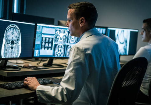 Two medical professionals examining magnetic resonance imaging scans. Examination at specialized medical clinic, diagnosis and healthcare concept.